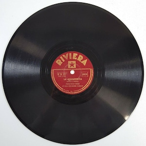 May include: A red and gold vinyl record label with the text "RIVIERA" in a gold font. The label also includes the text "RN 97", "PART 6709", "LA' CHOUPPEТТА", "OHANA IS GUERCO", "FRANCISCO CAVEZ", "ET SON ORCHESTRE CUBAIN", "MADE IN FRANCE", "BIEM", and a star.
