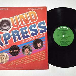 May include: A vintage vinyl record album titled "Sound Express" by Ronco Records. The album cover is red with the title in large, colorful letters and a speaker graphic. The album includes 18 original hits and features various artists.