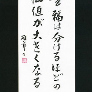 May include: Black and white calligraphy on a white background with a red seal. The text reads "The more happiness I shared, the more value it is".