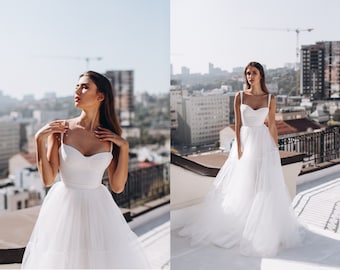 Simple A-line wedding dress with tiered tulle skirt and bustier bodice with sewn-in cups / Bustier wedding gown with open back / Rehearsal
