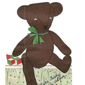 May include: A brown teddy bear with a green bow sitting on a green and white patterned surface. The bear is holding a red, white, and green block. The text "Make Teddy in any color." is written on the surface.