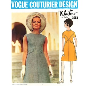 Może przedstawiać: Koperta z wykrojem krawieckim Vogue Couturier Design dla Valentino of Italy, numer 2063. Okładka zawiera zdjęcie szarej sukienki bez rękawów z futrzanym kapeluszem oraz ilustrację żółtej sukienki z krótkimi rękawami i detalami kieszeni.