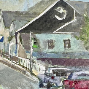 May include: A painting of a street scene with a building in the background. The building has a dark roof and a light blue facade. There are two windows on the facade. There are two cars parked in the street in front of the building. The car in the foreground is red. The car in the background is gray.