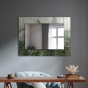 Puede incluir: Una silla tapizada azul con un escritorio de caballete de madera delante. El escritorio tiene un espejo con un diseño de hojas encima. La habitación tiene una pared gris y una puerta de madera.