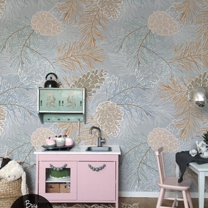 May include: A pink play kitchen with a white countertop and two doors. The kitchen has gray bead handles and is set against a wall with a gray and white pine cone wallpaper. The text "Buy on kidsColoray Etsy Shop" is visible in the bottom left corner of the image.
