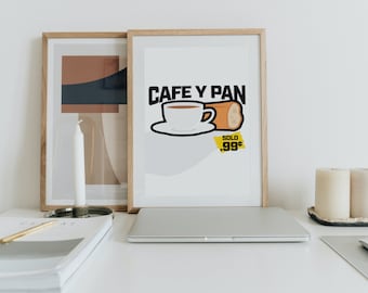 May include: A framed print with a white background and black text that reads "Cafe y Pan" with a cartoon illustration of a cup of coffee and a bread roll. The text "Solo .99¢" is in yellow.