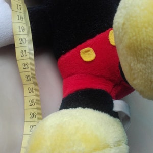 May include: A black and red plush Mickey Mouse toy with yellow shoes. The toy is 32 inches tall.