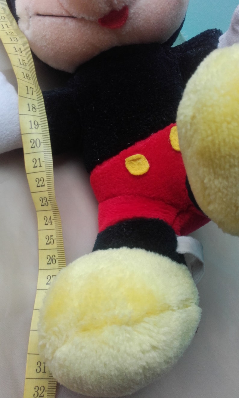 May include: A black and red plush Mickey Mouse toy with yellow shoes. The toy is 32 inches tall.