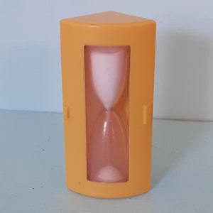 May include: A yellow hourglass with a white sand timer inside. The hourglass is shaped like a triangle and has a small opening at the top and bottom.