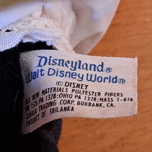 May include: White tag with blue text that reads "Disneyland Walt Disney World&reg;" and "&copy; DISNEY ALL NEW MATERIALS POLYESTER FIBERS 1525:PA 1378:OHIO PA 1378-MASS T-616 CANASA TRADING CORP. BURBANK, CA. PRODUCT OF SRILANKA".