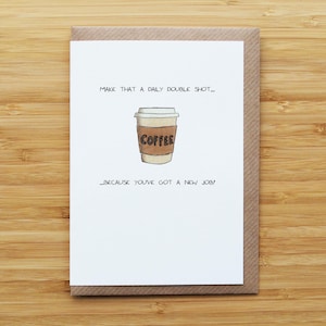 Könnte beinhalten: Eine Grußkarte mit einer Kaffeebecher-Illustration und dem Text "MAKE THAT A DAILY DOUBLE SHOT... COFFEE... BECAUSE YOU'VE GOT A NEW JOB!". Die Karte hat einen braunen Rand und liegt auf einem Holzgrund.