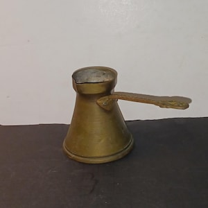 Antique Turkish Arabic copper coffee pot pourer with an ornate brass handle.