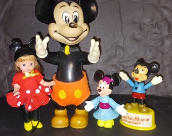 Vintage Disney toy figurines. Four in all. 8" rubber squeak toy, 1977 Mickey push up puppet, Musketeer doll and Epcot center figurine.
