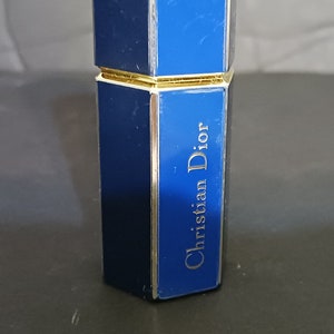 May include: A blue and gold perfume bottle with the text "Christian Dior" on the side.