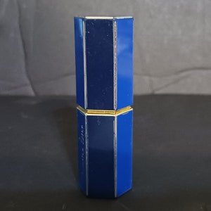 May include: A blue and gold octagonal lipstick tube.