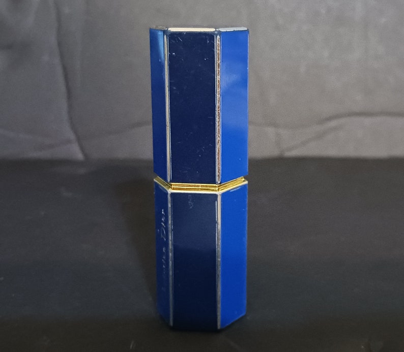 May include: A blue and gold octagonal lipstick tube.