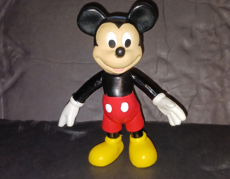K&ouml;nnte beinhalten: Eine schwarze und rote Mickey Mouse Figur aus Plastik mit gelben Schuhen. Die Figur steht mit ausgestreckten Armen.