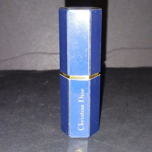 May include: A blue and gold octagonal shaped perfume bottle with the text "Christian Dior" on the front.