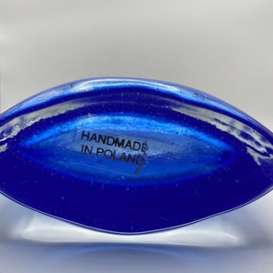 K&ouml;nnte beinhalten: Eine blaue Glasvase mit abgerundeter Form. Der Boden der Vase tr&auml;gt ein Etikett mit der Aufschrift "Handmade in Poland".
