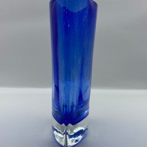 K&ouml;nnte beinhalten: Eine kobaltblaue Glasvase mit einem klaren Glasfu&szlig;. Die Vase hat eine abgerundete, leicht ausgestellte &Ouml;ffnung und einen spitzen Fu&szlig;.