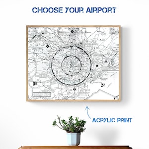 May include: A black and white aerial map of Charleston, South Carolina, with the text "CHOOSE YOUR AIRPORT" at the top. The map is framed in a light brown wood frame and is labeled "ACRYLIC PRINT" below the frame.