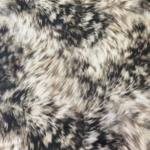 Puede incluir: Primer plano de una tela con un patrón de piel sintética. El patrón presenta una mezcla de fibras negras, grises y blancas, creando una apariencia texturizada y similar a la de un animal. Las fibras son largas y fluidas, dando a la tela un aspecto suave.