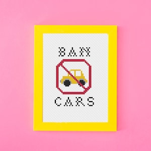 May include: A yellow frame with a white background and the words "BAN CARS" in black letters. A red circle with a diagonal line through it contains a yellow car.