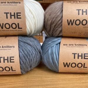 May include: Four balls of yarn in different colors, including white, beige, gray, and blue. Each ball has a label that reads "We Are Knitters" and "The Wool" with the percentage of wool content.