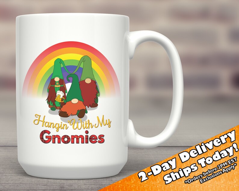 May include: White ceramic coffee mug featuring a rainbow and three gnomes holding a beer mug. The text "Hangin' With My Gnomies" is printed on the mug.