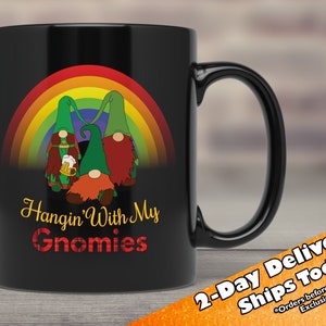 May include: Black ceramic coffee mug featuring a rainbow and three gnomes holding beer mugs. The text "Hangin' With My Gnomies" is printed on the mug.