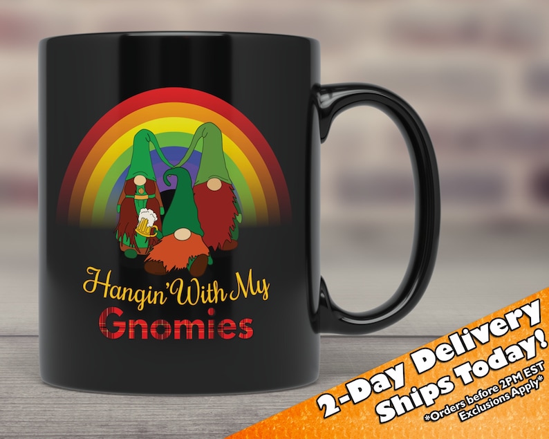 May include: Black ceramic coffee mug featuring a rainbow and three gnomes holding beer mugs. The text "Hangin' With My Gnomies" is printed on the mug.