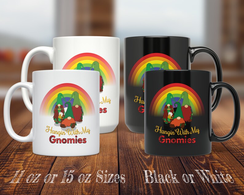 May include: Two ceramic coffee mugs featuring a rainbow and gnome design. The text on the mugs reads "Hangin' With My Gnomies". The mugs are available in 11 oz or 15 oz sizes and in black or white.