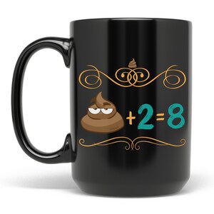 May include: Black coffee mug with a brown cartoon poop emoji with eyes and a gold design that says " +2 = 8 "