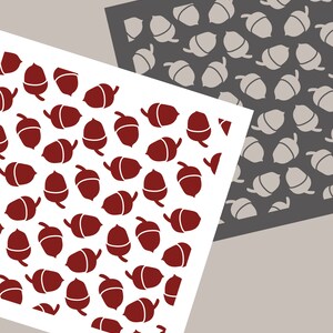 May include: Two white squares with a pattern of red acorns on one and gray acorns on the other. The text "Joyous Times" is written in black at the bottom of the image.