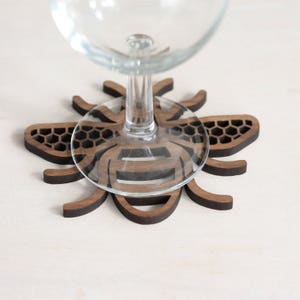 Manchester Bee Coaster under a wine glass