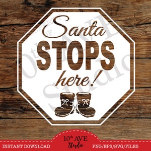May include: White octagon-shaped sign with the text "Santa Stops Here!" in black lettering.  Two black boots with white trim are below the text. The sign is on a brown wooden background.