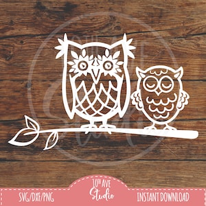 May include: A white outline of two owls perched on a branch. The larger owl has a detailed design on its feathers and the smaller owl has a simpler design. The owls are facing the viewer.