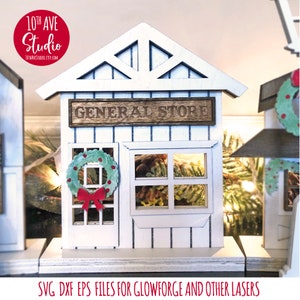 May include: A white wooden general store building with a green wreath on the door and a window with pine cones. The sign above the door reads "GENERAL STORE".