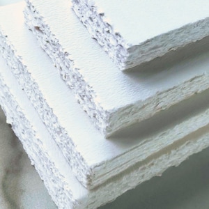 Stack of several sizes of blank Deckle Edge Paper, showing the torn edge closer up