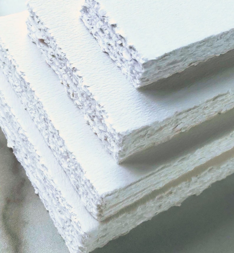 Stack of several sizes of blank Deckle Edge Paper, showing the torn edge closer up