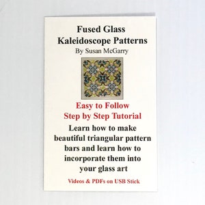 May include: A white card with the title "Fused Glass Kaleidoscope Patterns" by Susan McGarry. The card features a small image of a colorful kaleidoscope pattern and text that reads "Easy to Follow Step by Step Tutorial Learn how to make beautiful triangular pattern bars and learn how to incorporate them into your glass art Videos & PDFs on USB Stick."