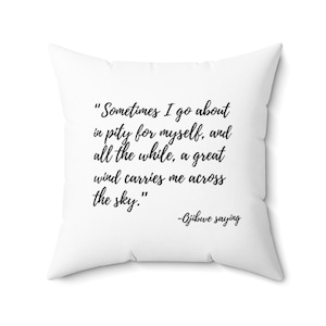 May include: White throw pillow with black text that reads "Sometimes I go about in pity for myself, and all the while, a great wind carries me across the sky." -Ojibwe saying
