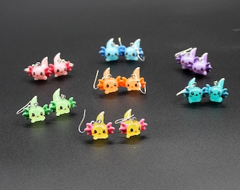 Peut inclure: Un ensemble de 10 boucles d'oreilles axolotl de différentes couleurs, dont le rose, le bleu, le vert et le jaune. Chaque boucle d'oreille représente un mignon axolotl avec un visage souriant et une paire de branchies plumeuses.