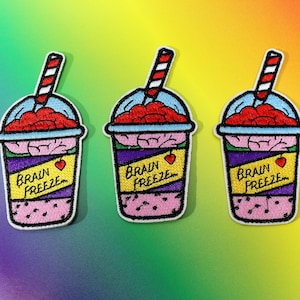 May include: Three embroidered iron-on patches featuring a brain-shaped ice cream cone with a red and white striped straw and the text "Brain Freeze".