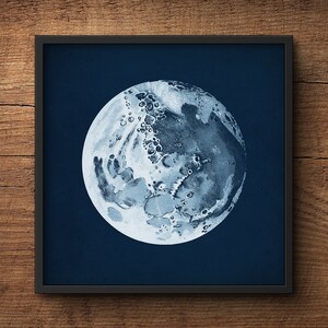 May include: A black framed print of a detailed illustration of the moon on a dark blue background.