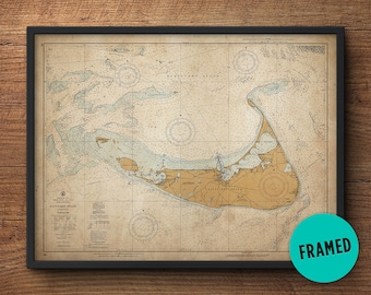 May include: A framed vintage nautical chart of Nantucket Island, Massachusetts. The chart is printed on aged paper with a light brown background and blue lines. The chart includes details of the island's coastline, waterways, and surrounding areas. The chart is framed in a black frame.