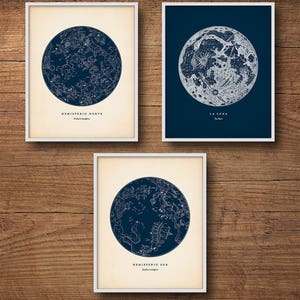 May include: Three framed prints with a blue background. The top left print shows a map of the Northern Hemisphere with constellations. The top right print shows a detailed map of the moon. The bottom print shows a map of the Southern Hemisphere with constellations. All three prints have the title in Italian.