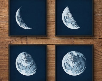 May include: Four framed prints of the moon in different phases. Each print features a blue background with a white moon in a different phase, from a crescent to a full moon.