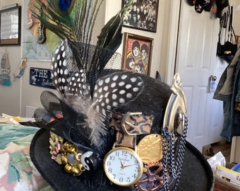 Mini chapeau haut de forme unique steampunk avec plumes, montre et décoration. Livré avec un serre-tête. 7 po. lo x 6 po. l. 7 po. de hauteur