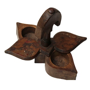May include: A wooden spice rack shaped like a flower with three compartments. The rack has a handle on top and is made of dark brown wood.